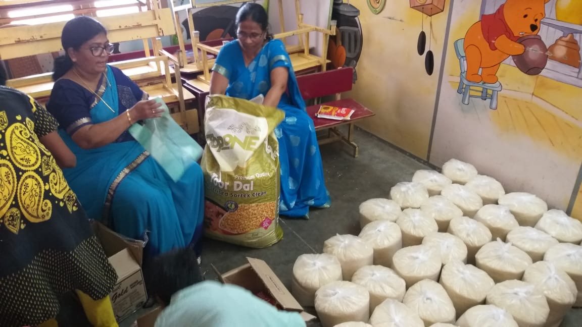 Indische Frauen packen Nahrungsmittel für Familien